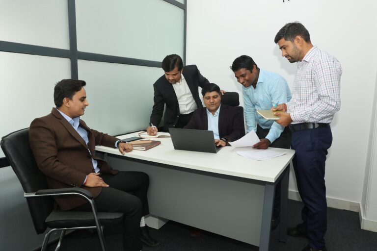 EXP team members reviewing work together around a desk in the Jaipur office